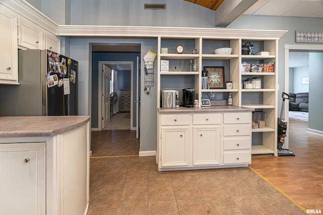 kitchen with open shelves, light wood-style flooring, freestanding refrigerator, and baseboards