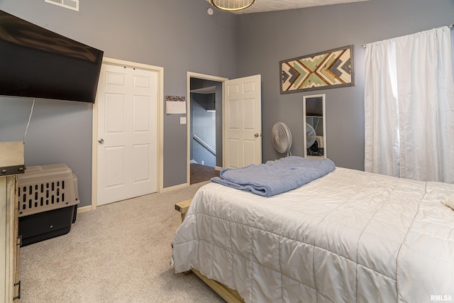 bedroom featuring baseboards, visible vents, vaulted ceiling, and light colored carpet