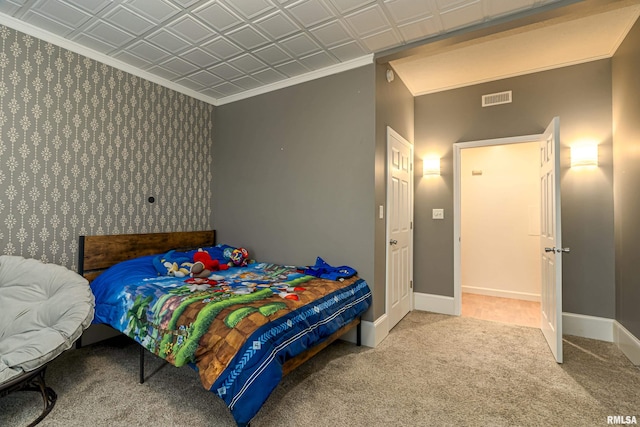 carpeted bedroom with an ornate ceiling, baseboards, visible vents, and ornamental molding