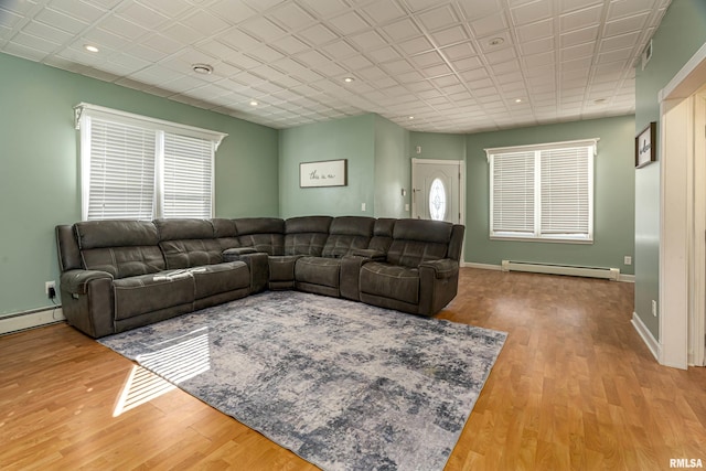 living area featuring recessed lighting, a baseboard radiator, wood finished floors, and baseboards