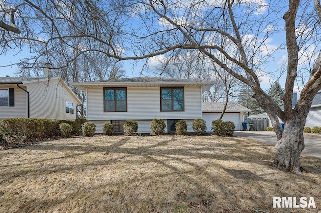 view of front facade with a front lawn, an attached garage, and driveway