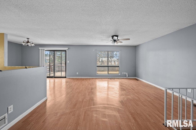 unfurnished room with baseboards, wood finished floors, and ceiling fan with notable chandelier