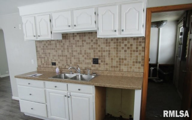 kitchen featuring backsplash, dark wood-style flooring, white cabinets, and a sink