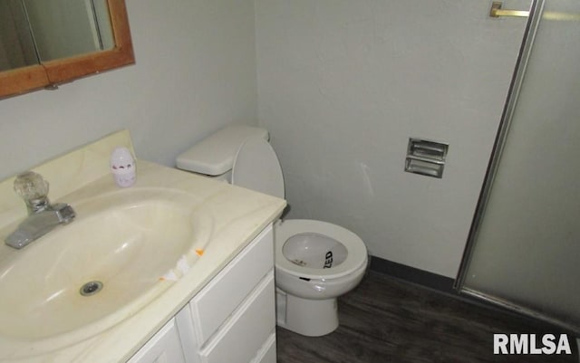 bathroom featuring vanity, toilet, and wood finished floors