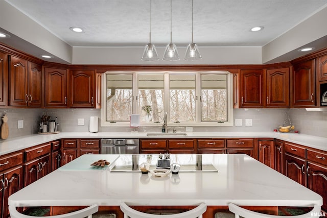 kitchen featuring stainless steel appliances, a breakfast bar, light countertops, and a sink