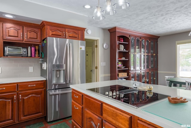 kitchen featuring open shelves, light countertops, stainless steel fridge, and black electric cooktop