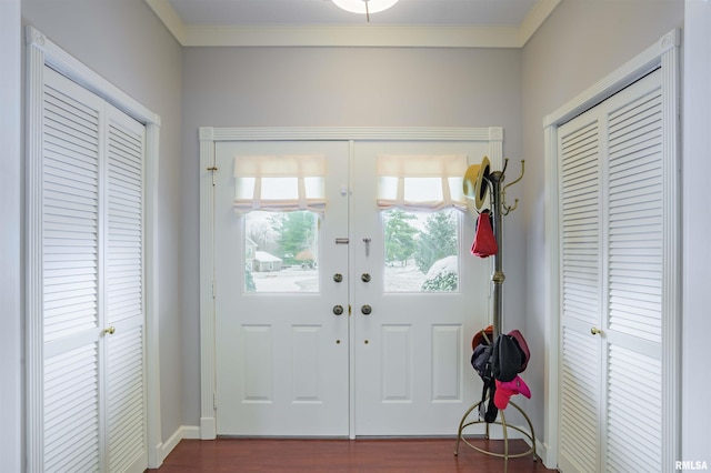 entryway featuring crown molding, baseboards, and dark wood-style flooring