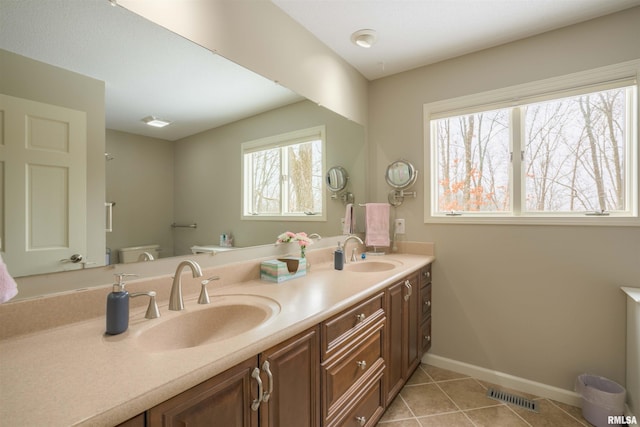 full bath with baseboards, tile patterned flooring, visible vents, and a sink