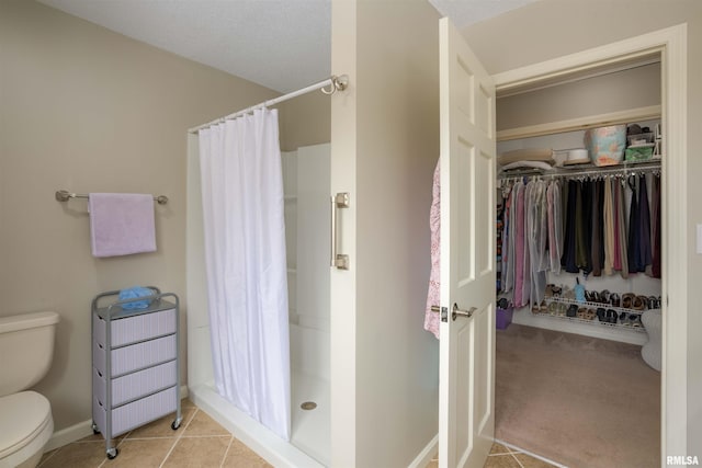 bathroom with baseboards, toilet, radiator heating unit, tile patterned flooring, and a shower stall