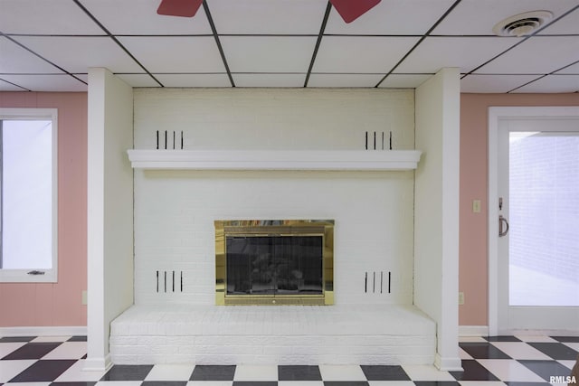 details with a paneled ceiling, a fireplace, visible vents, and tile patterned floors