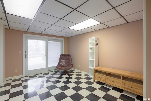 unfurnished room with a paneled ceiling, baseboards, and tile patterned floors