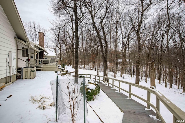 yard covered in snow featuring a deck