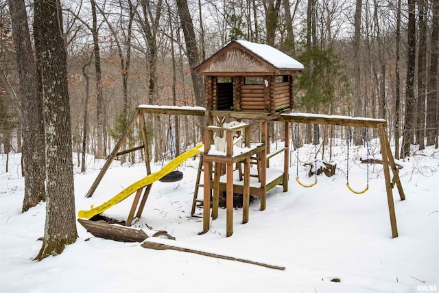 snow covered playground with a wooded view