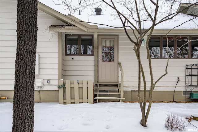 snow covered property entrance featuring crawl space