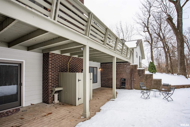 snow covered patio featuring a deck