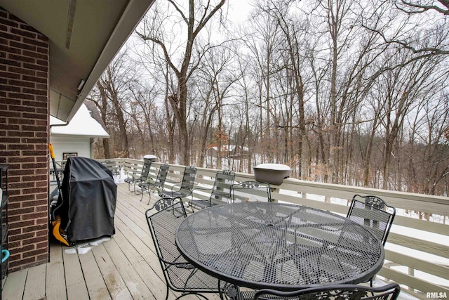 wooden deck featuring outdoor dining area and a grill