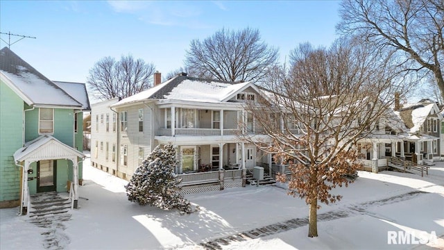 view of front of property with covered porch, driveway, and a chimney