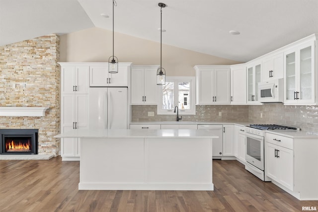 kitchen featuring white appliances, light countertops, and hanging light fixtures