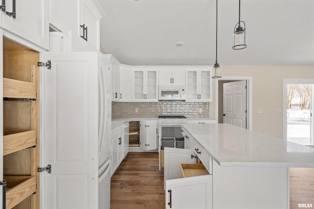 kitchen with glass insert cabinets, white cabinetry, and white microwave