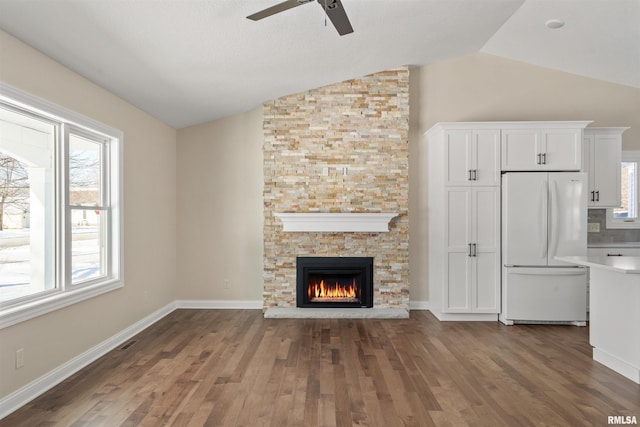 unfurnished living room featuring lofted ceiling, dark wood-type flooring, visible vents, and baseboards