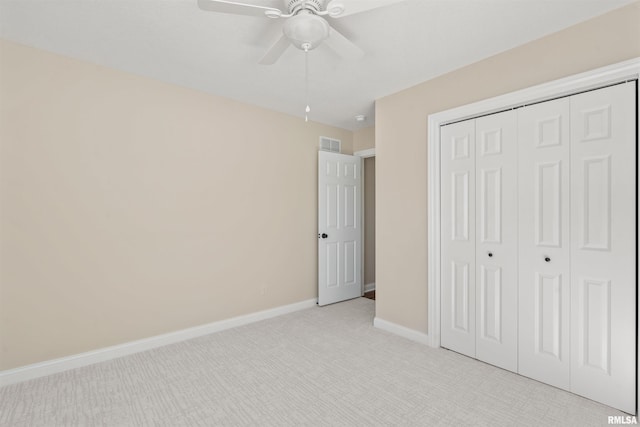 unfurnished bedroom with ceiling fan, light colored carpet, visible vents, baseboards, and a closet