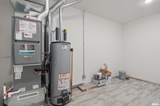 utility room featuring gas water heater and heating unit