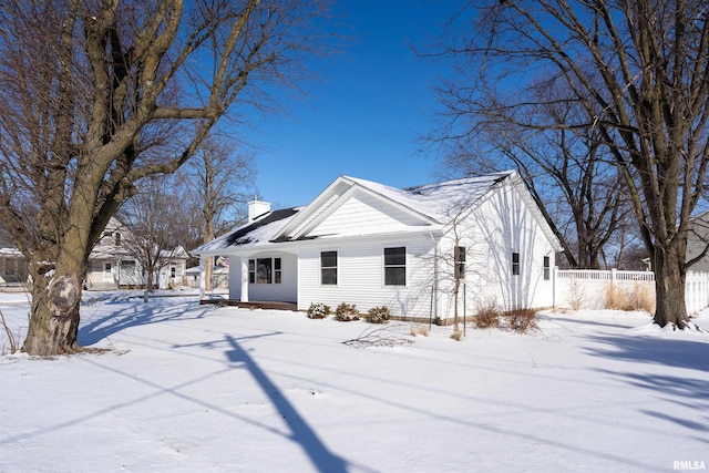 view of snow covered exterior featuring fence