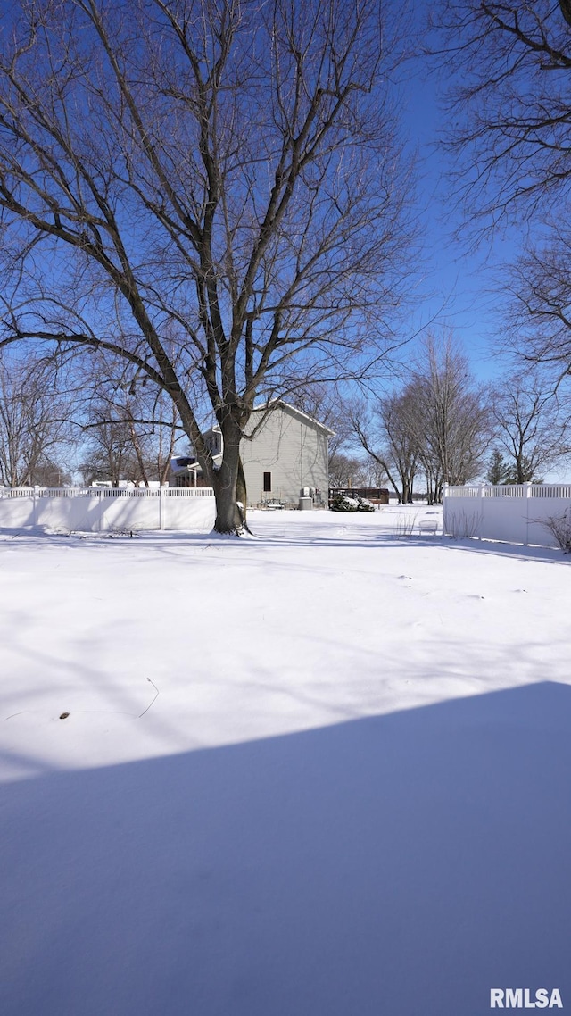 yard covered in snow featuring fence