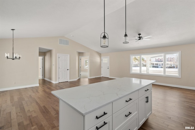 kitchen with visible vents, white cabinets, open floor plan, a center island, and hanging light fixtures