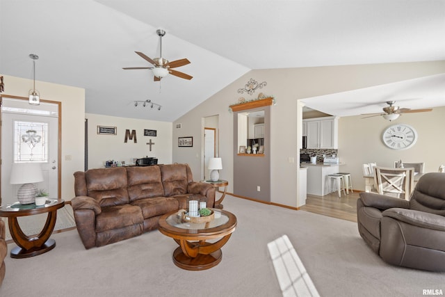 living area with light carpet, baseboards, vaulted ceiling, and a ceiling fan