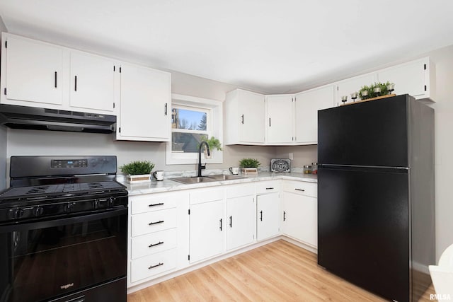 kitchen featuring white cabinets, under cabinet range hood, light countertops, black appliances, and a sink