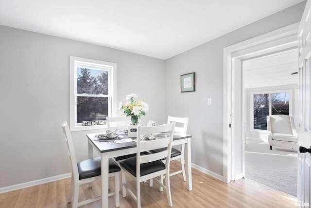 dining area with baseboards and light wood-style floors