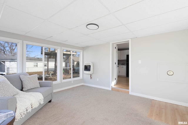 unfurnished room with a healthy amount of sunlight, carpet, a paneled ceiling, and heating unit