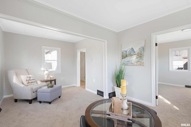 living area with a healthy amount of sunlight, crown molding, and light colored carpet