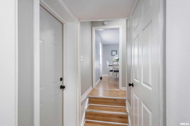 staircase featuring baseboards and wood finished floors