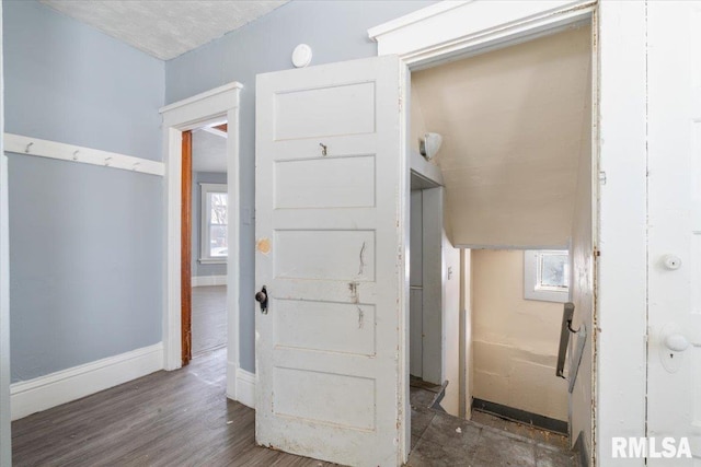 hall with dark wood-style floors and baseboards