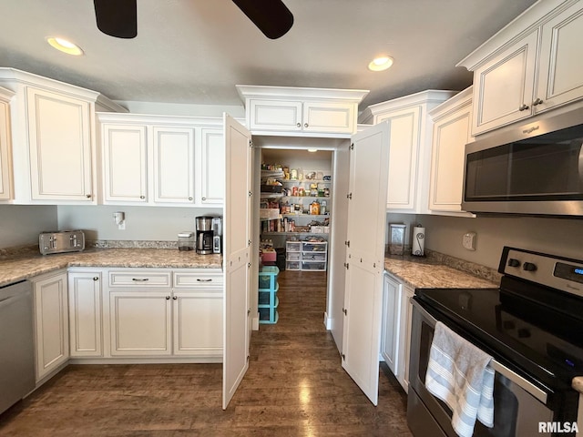 kitchen with appliances with stainless steel finishes, dark wood-type flooring, ceiling fan, and light stone countertops