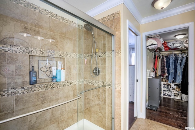 full bathroom with a spacious closet, a stall shower, and crown molding