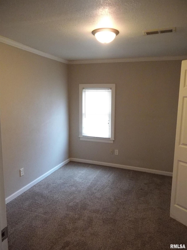 empty room featuring baseboards, visible vents, dark colored carpet, and crown molding