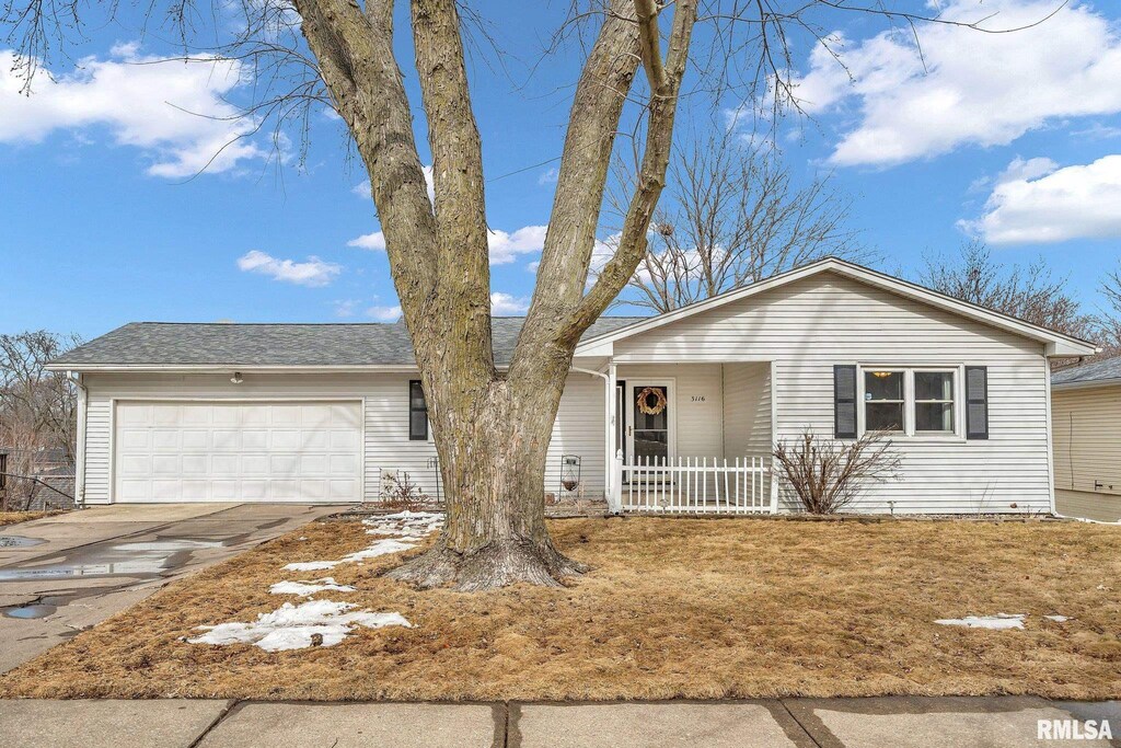 single story home featuring driveway, covered porch, a garage, and roof with shingles