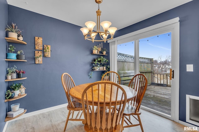 dining room with light wood-type flooring, baseboards, and a chandelier