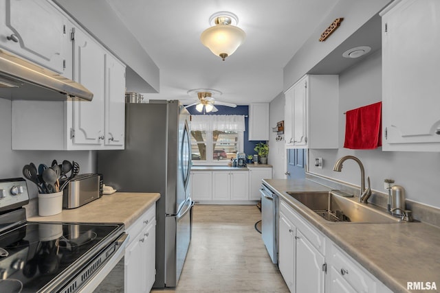 kitchen with stainless steel appliances, a sink, light countertops, and white cabinets