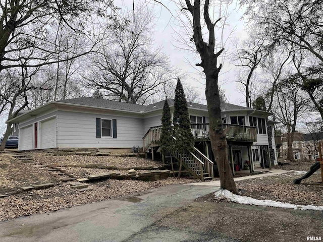 view of front facade featuring a garage, stairway, and a deck