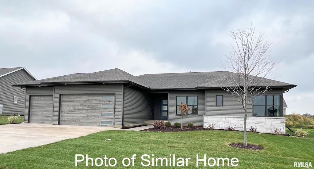view of front facade with a shingled roof, an attached garage, driveway, and a front yard