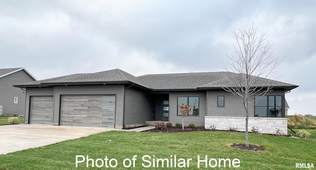 view of front facade featuring a front lawn, concrete driveway, a shingled roof, and an attached garage