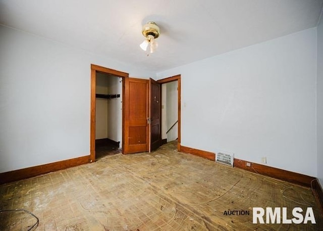 unfurnished bedroom with a closet, visible vents, and baseboards