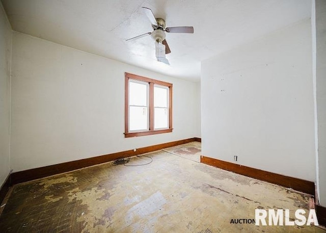 spare room featuring baseboards and a ceiling fan