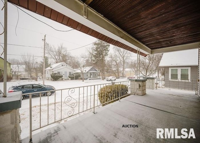 snow covered patio featuring a residential view