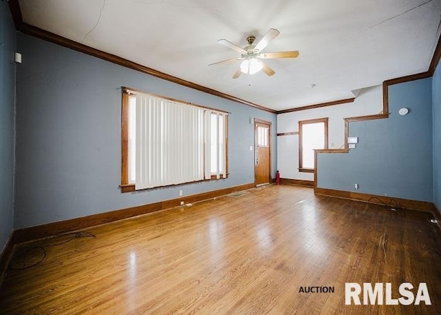 unfurnished room with baseboards, wood finished floors, a ceiling fan, and crown molding