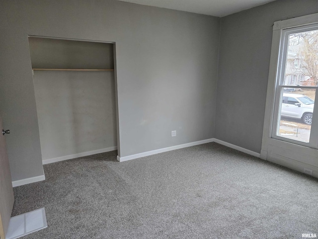 unfurnished bedroom with baseboards, carpet, visible vents, and a closet